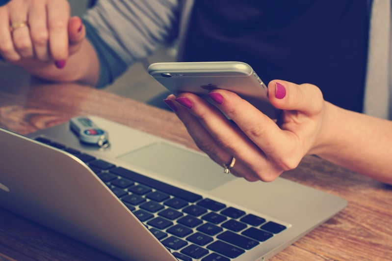person sitting at desk looking at phone